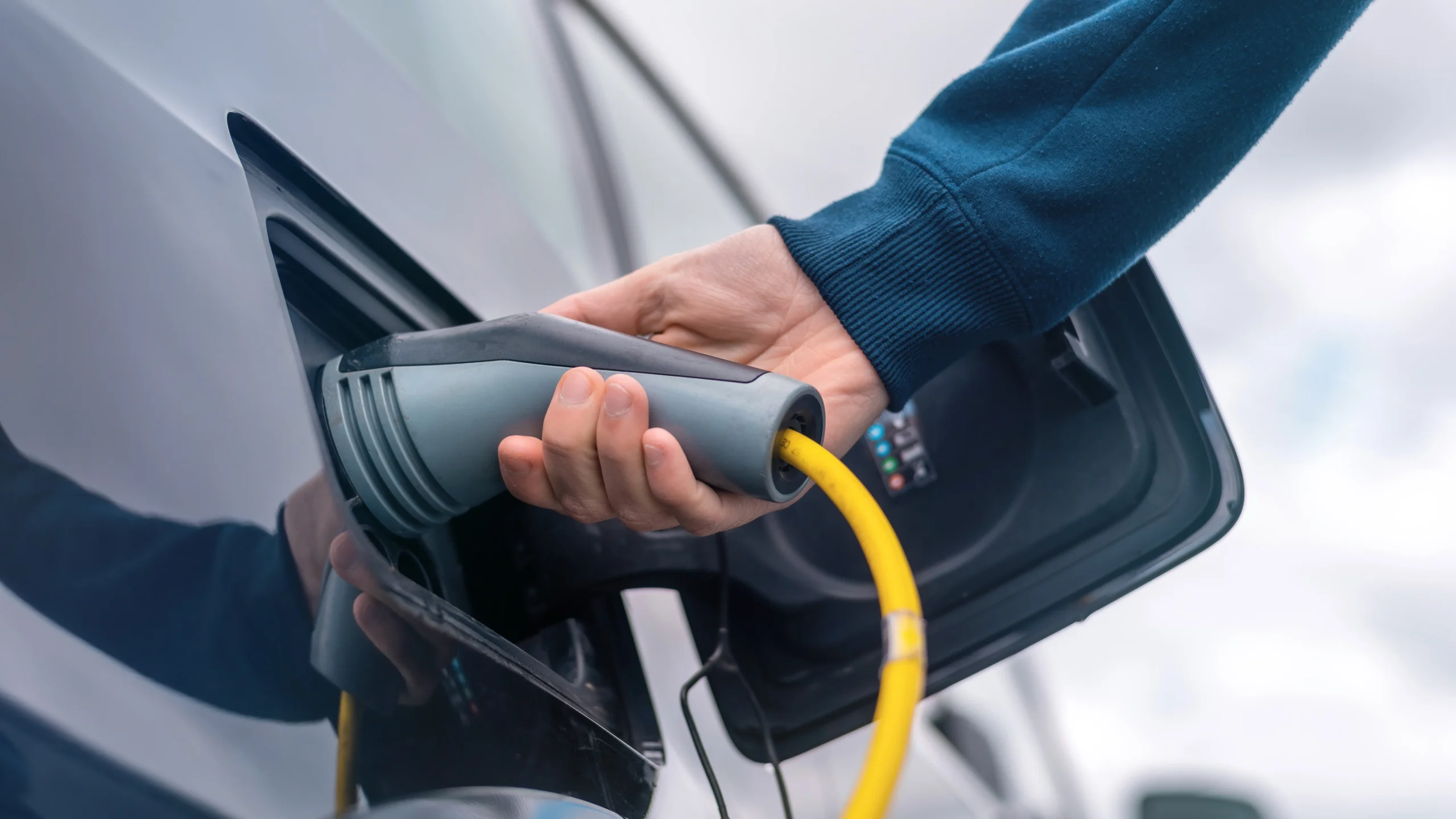 Homme branchant câble véhicule électrique borne service partagé recharge flotte pool