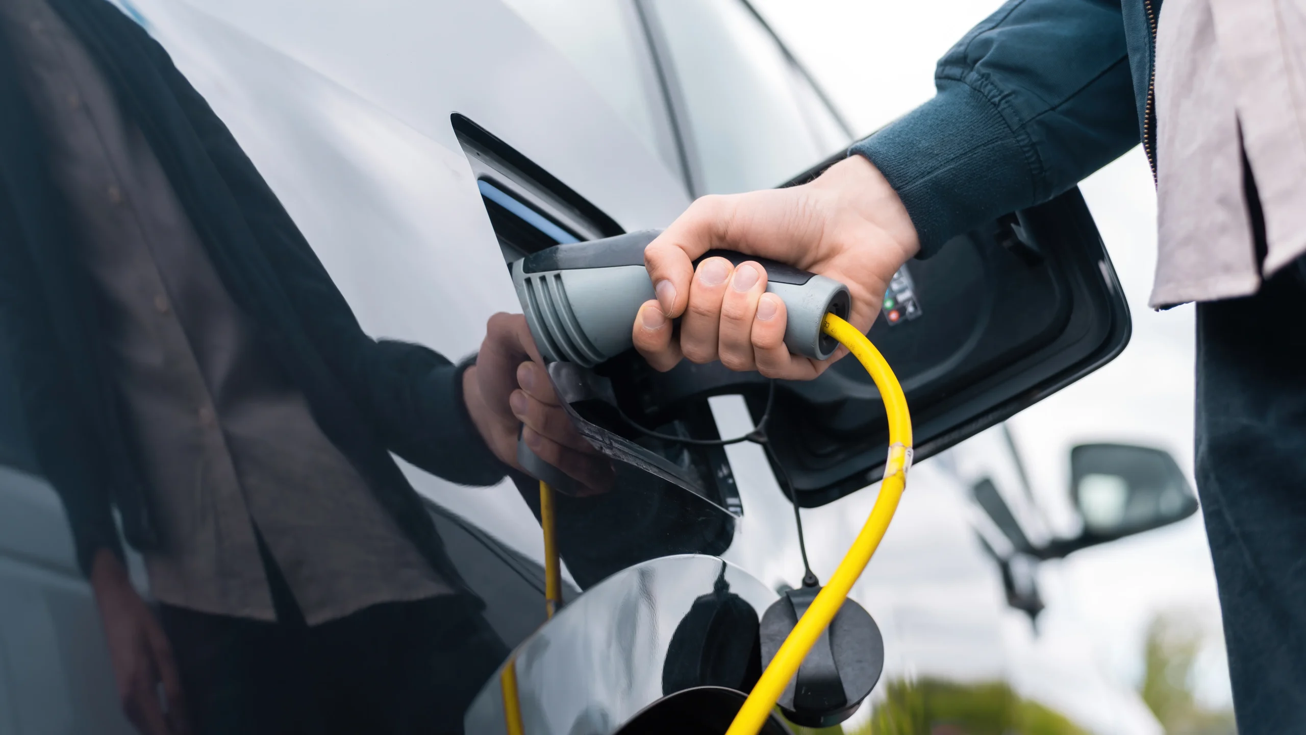 Homme branche câble recharge véhicule électrique partagé flotte service