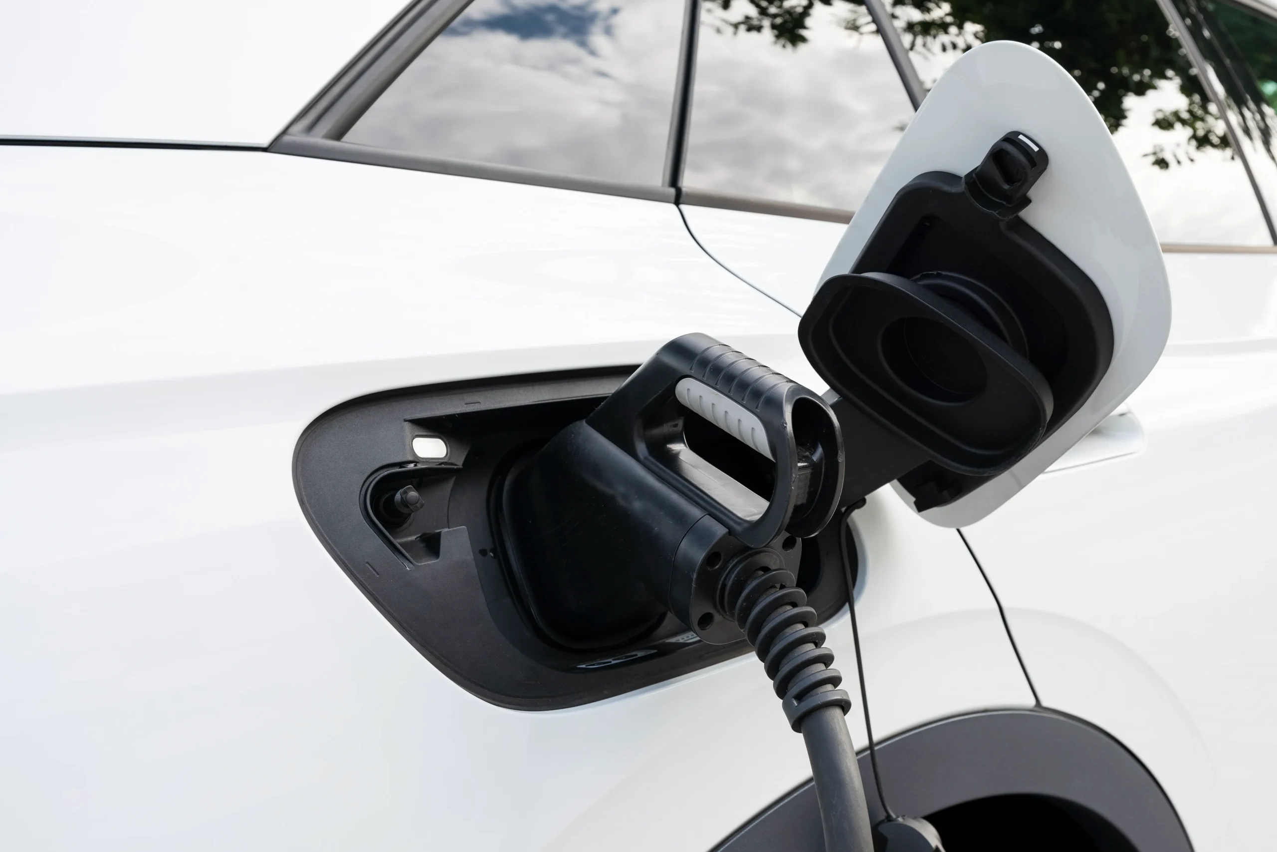 Voiture électrique blanche sur station de recharge frais TVA déductibles