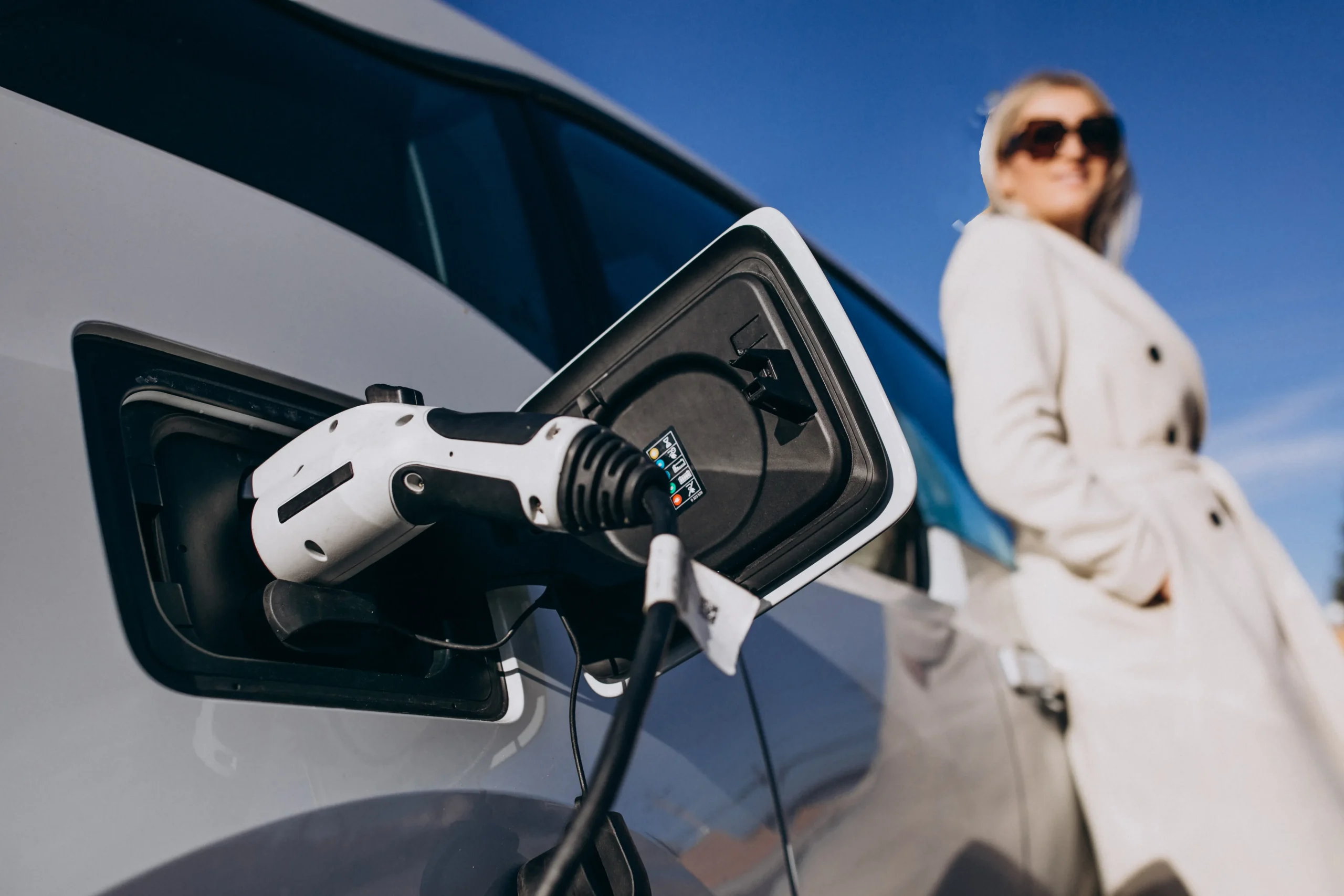 Femme rechargeant voiture électrique domicile professionnelle santé tournée