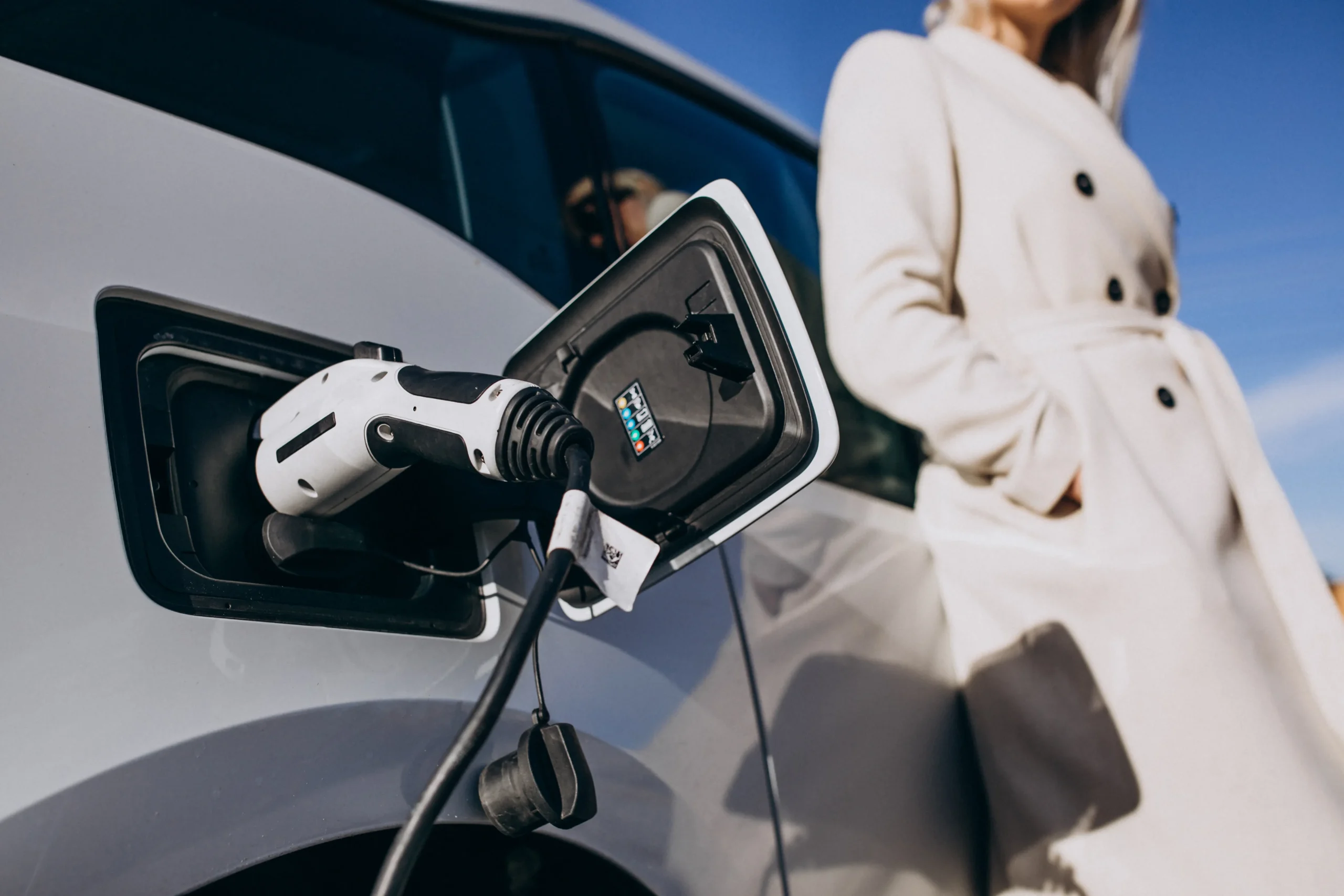 Femme rechargeant voiture électrique domicile professionnelle santé flotte médicale sanitaire