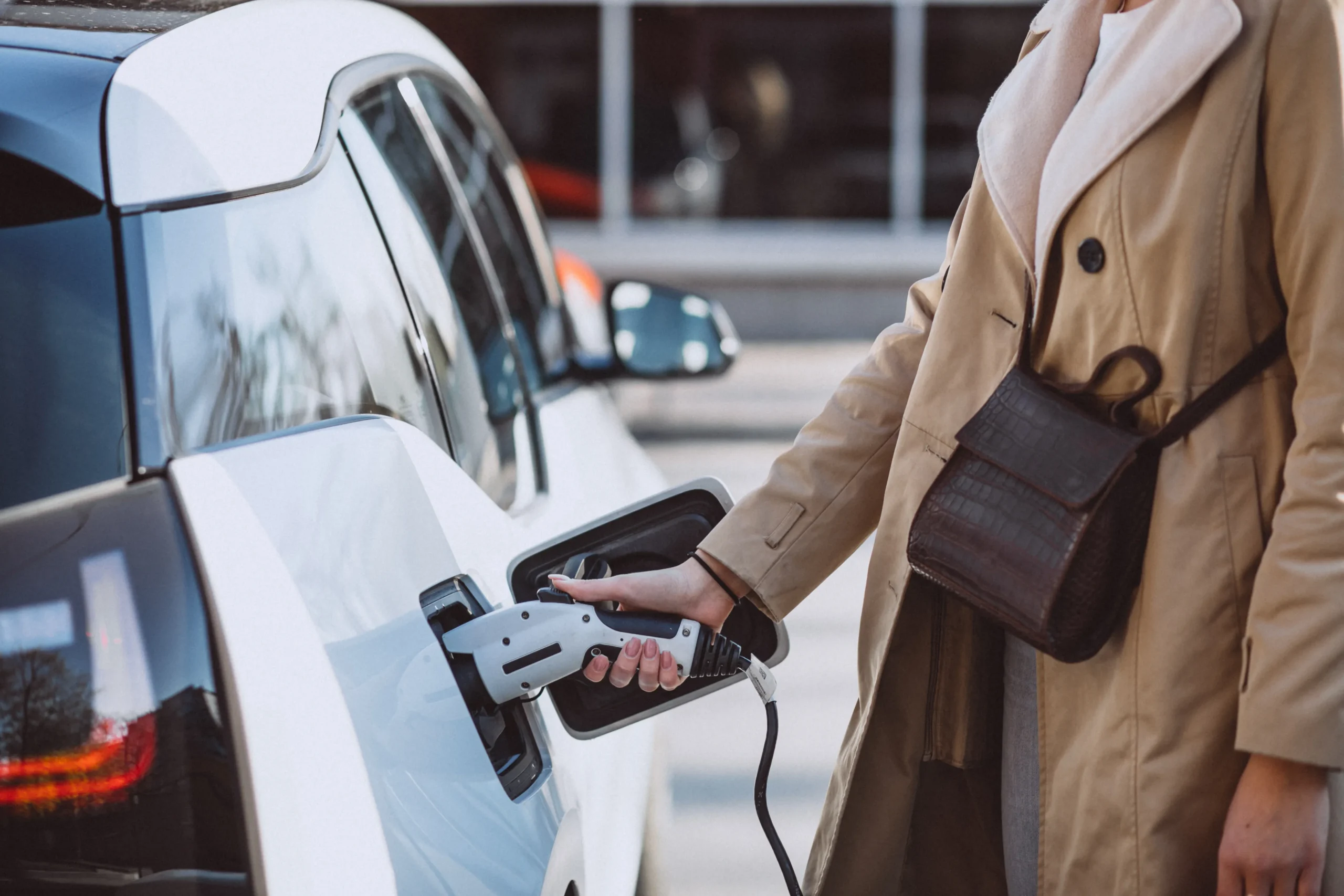 Femme rechargeant voiture électrique station service déplacement professionnel note frais remboursement